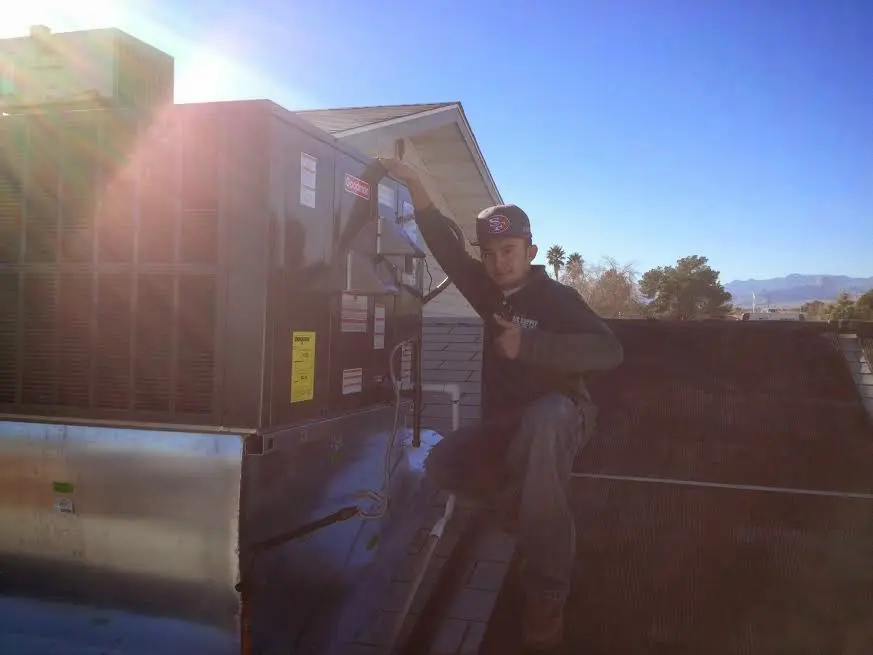 HVAC technician performing Boiler Repair on a rooftop unit in Neshannock